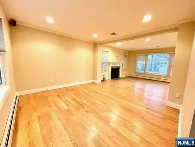 a view of an empty room with a fireplace and a window