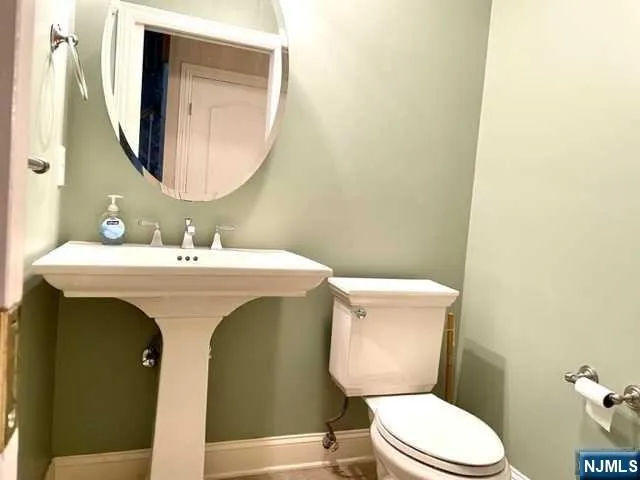 a bathroom with a toilet a sink and mirror