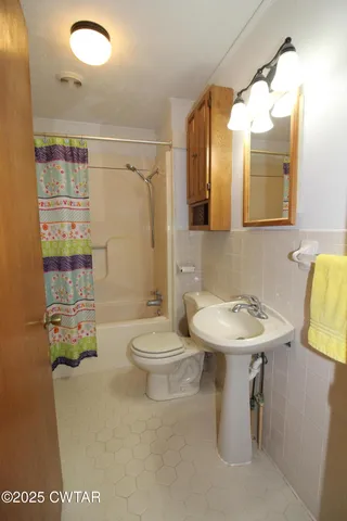 a bathroom with a toilet tub and sink