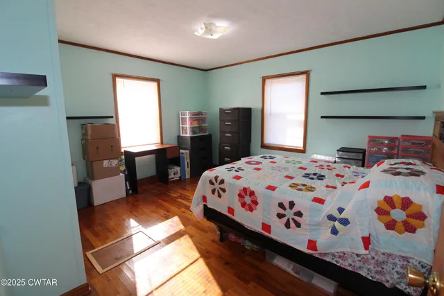 a bedroom with a bed and wooden floor
