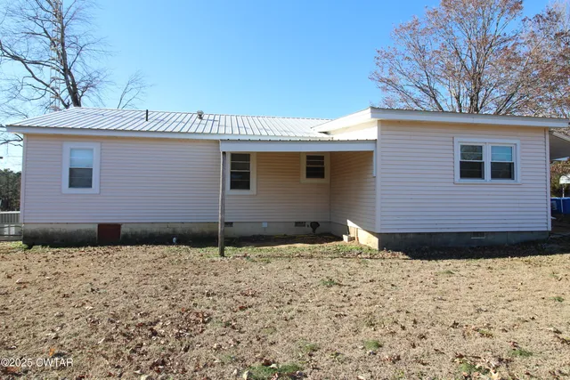 a view of a field and trees in the background