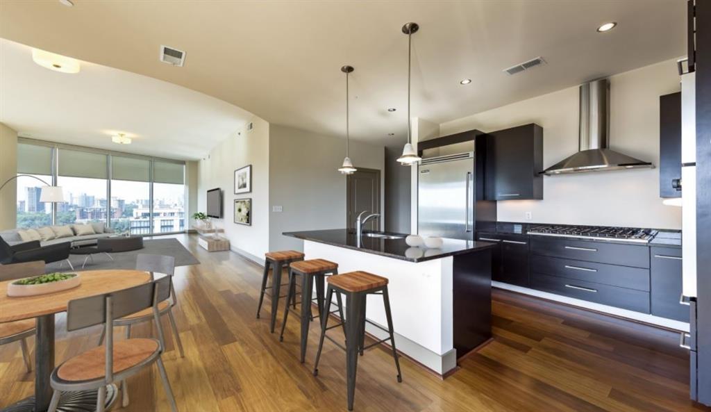 2171 Peachtree Road, Unit 1403 Atlanta, GA 30309 - Photo 3 of 25 a kitchen with a table chairs refrigerator and microwave