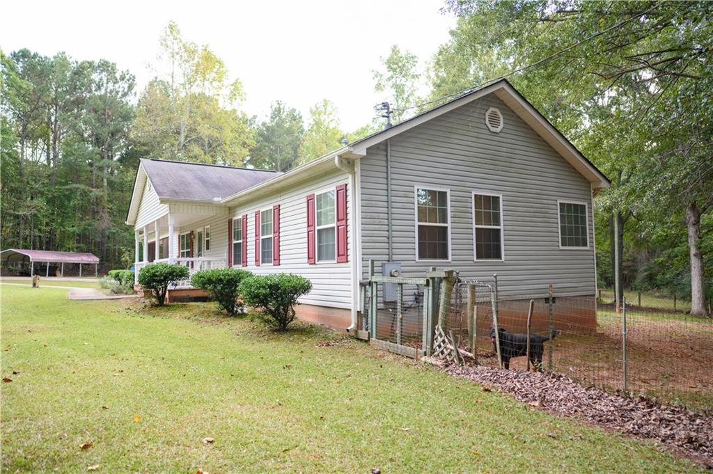 1581 Highway 77 Union Point, GA 30669 - Photo 15 of 17 a view of a house with a yard chairs and floor to ceiling window