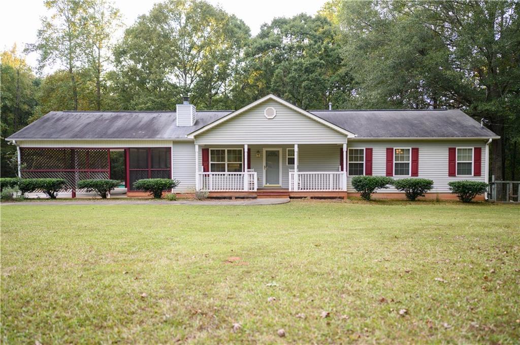 1581 Highway 77 Union Point, GA 30669 - Photo 2 of 17 a front view of a house with swimming pool and large trees
