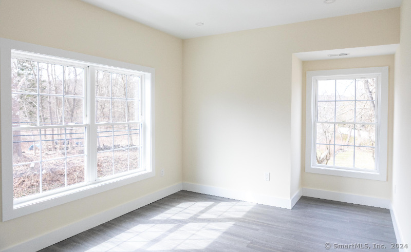 887 Federal Road, Unit 5 Brookfield, CT 06804 - Photo 12 of 15 an empty room with wooden floor and windows