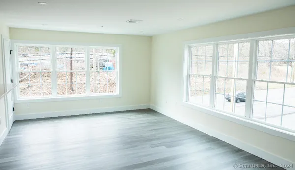 a view of a hallway with wooden floor and closet