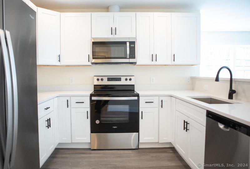 887 Federal Road, Unit 5 Brookfield, CT 06804 - Photo 2 of 15 a kitchen with white cabinets and stainless steel appliances