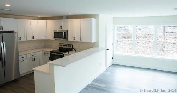 a kitchen with stainless steel appliances a refrigerator stove microwave and sink