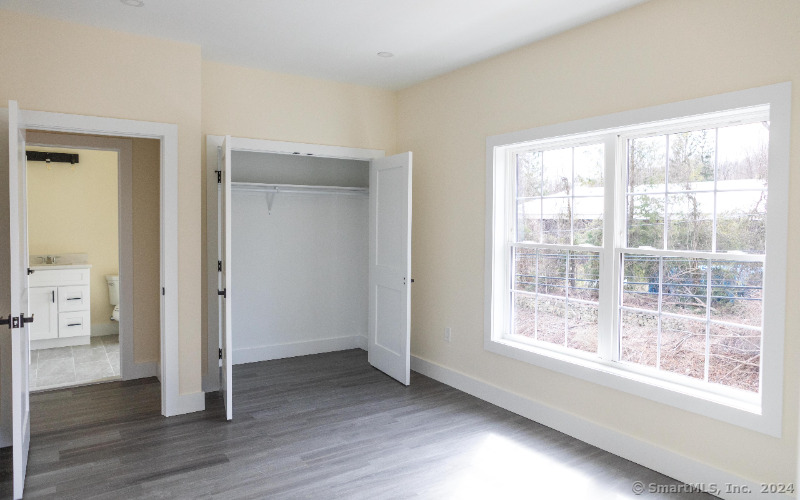 887 Federal Road, Unit 5 Brookfield, CT 06804 - Photo 7 of 15 a view of an empty room with wooden floor and a window