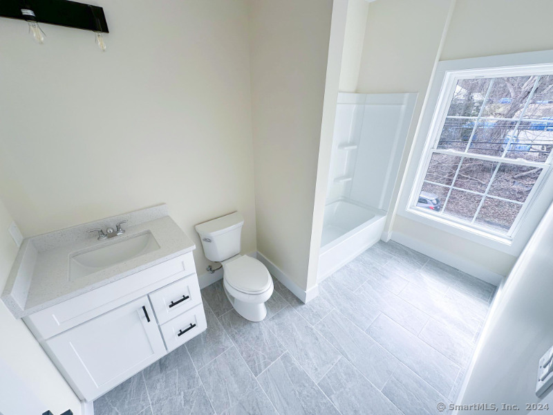 887 Federal Road, Unit 5 Brookfield, CT 06804 - Photo 9 of 15 a spacious bathroom with a toilet sink and a mirror