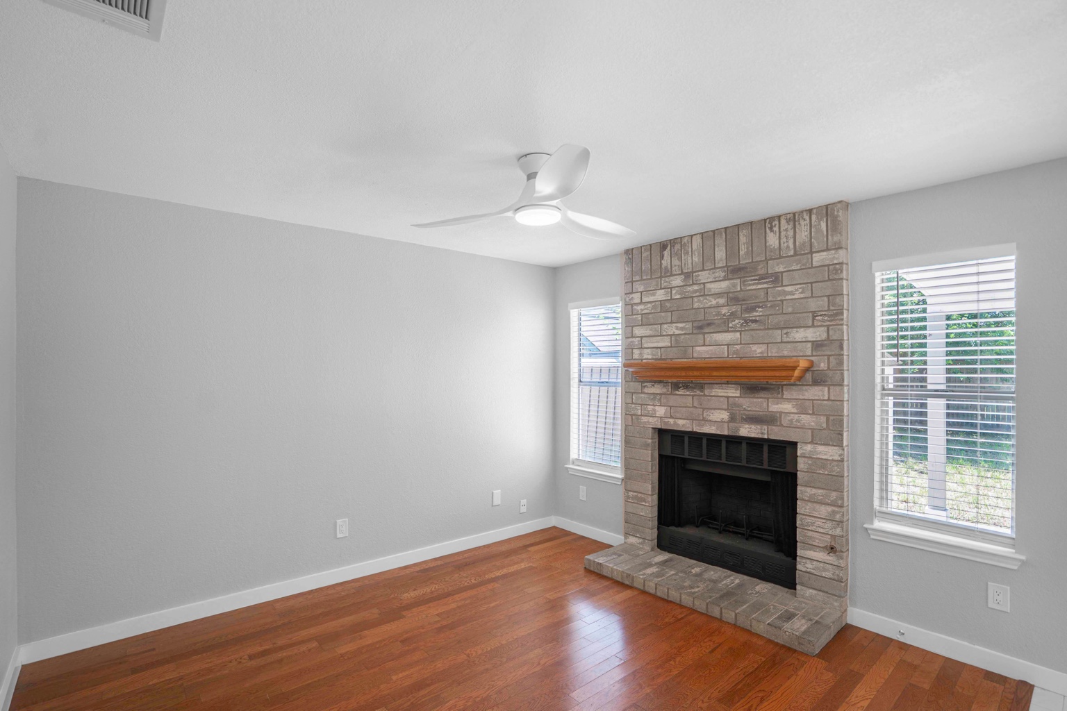 800 Smoke Signal Pass Pflugerville, TX 78660 - Photo 34 of 40 Warm hardwood flooring and a classic brick fireplace anchor this welcoming living space.
