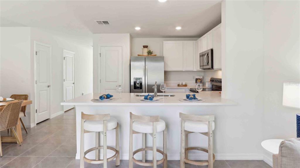 8196 Southwest 67th Avenue Ocala, FL 34476 - Photo 4 of 20 a kitchen with stainless steel appliances kitchen island granite countertop a table and chairs