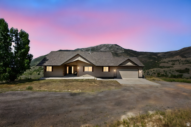2013 North River View Road Huntsville, UT 84317 - Photo 42 of 53 View of front facade featuring driveway, an attached garage, and a mountain view