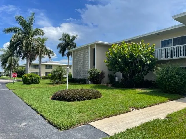 a view of a house with a yard and potted plants