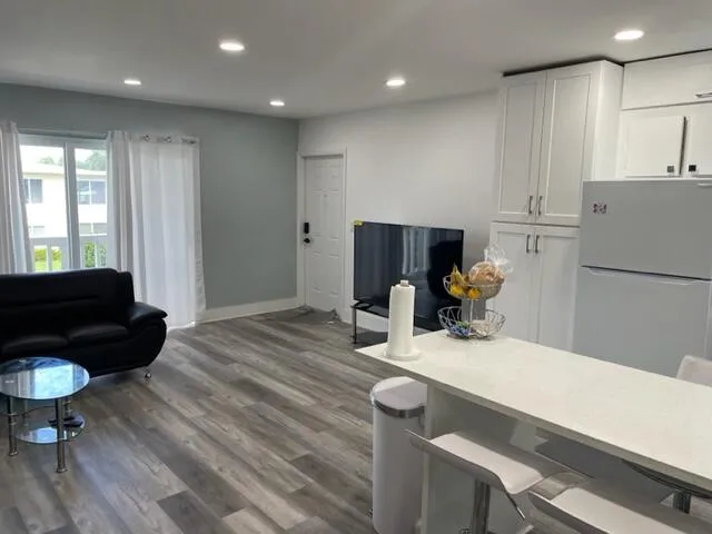a kitchen with a table chairs refrigerator and couch