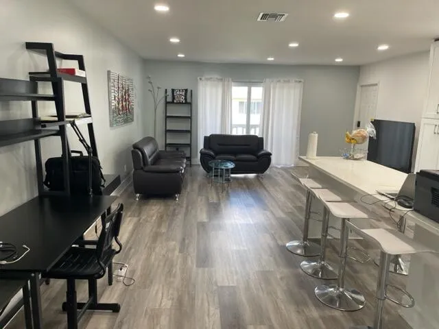 a living room with furniture a desk and chair with wooden floor