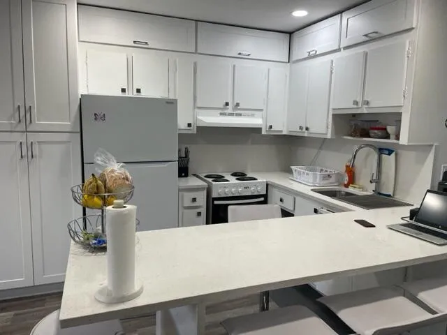 a kitchen with stainless steel appliances white cabinets sink and stove