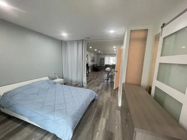 a view of a hallway with wooden floor and living room
