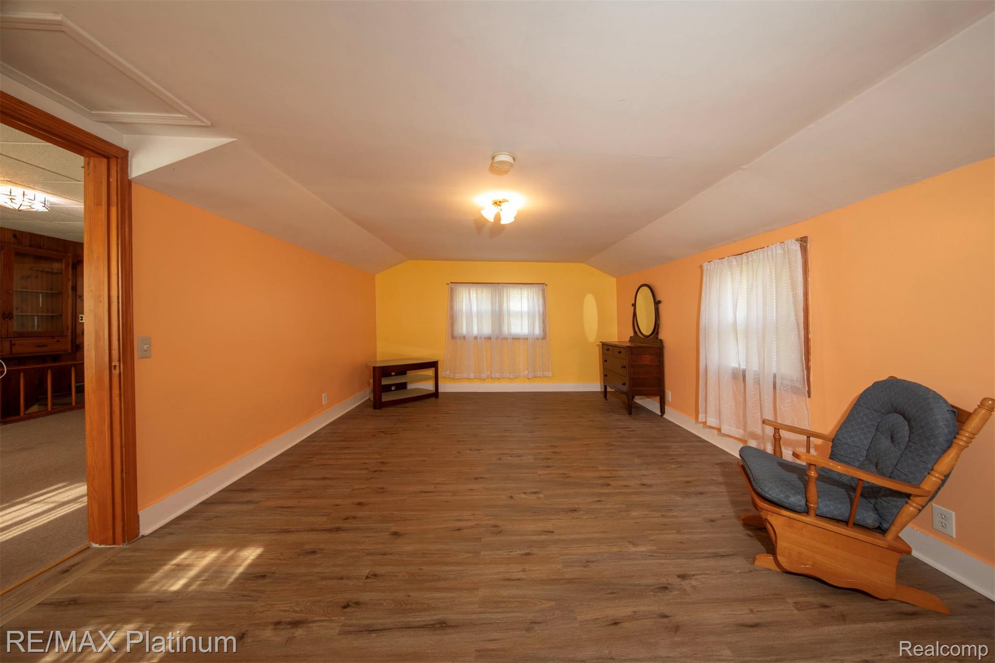 18696 Inkster Road Redford, MI 48240 - Photo 8 of 14 Expansive room featuring wood-finish flooring, multiple windows with white curtains, a built-in wooden column, and a ceiling light fixture
