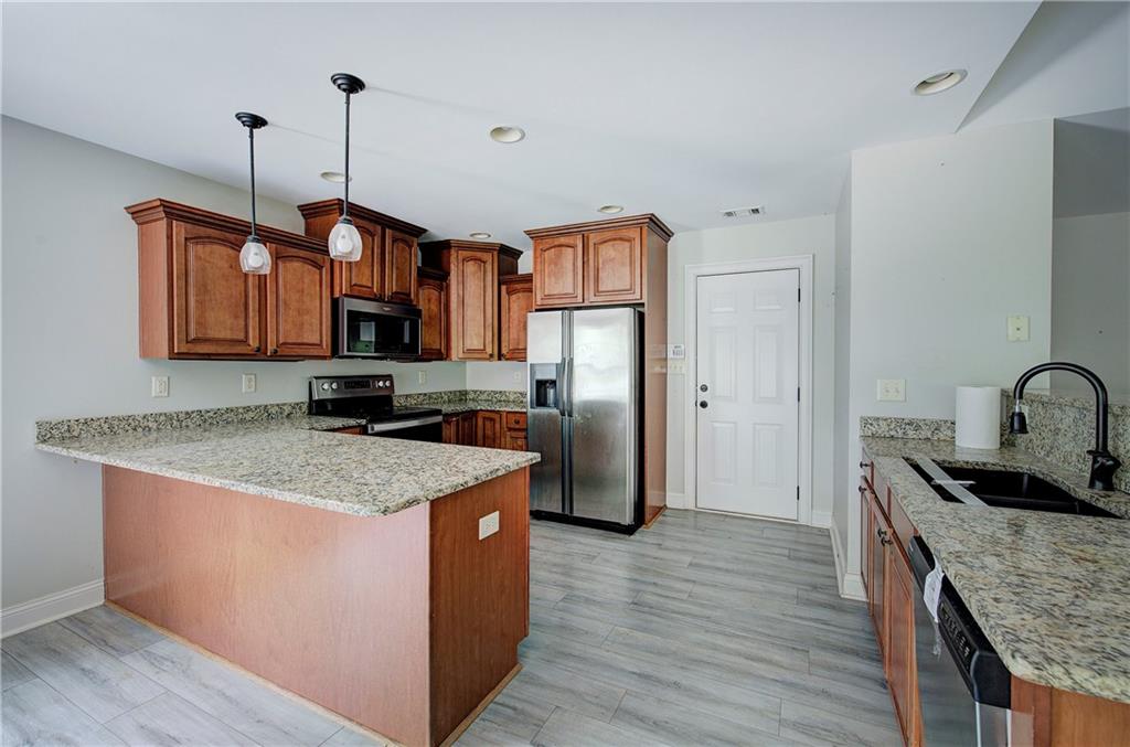 561 Holland Road Dallas, GA 30157 - Photo 12 of 48 a kitchen with stainless steel appliances granite countertop a sink stove and refrigerator