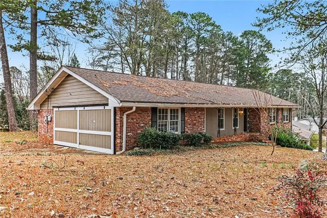 a view of a house with a yard and large trees