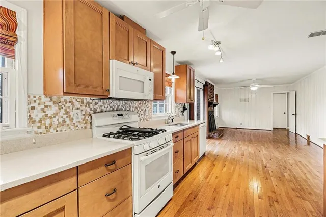 a kitchen with stainless steel appliances granite countertop a stove and a wooden floors