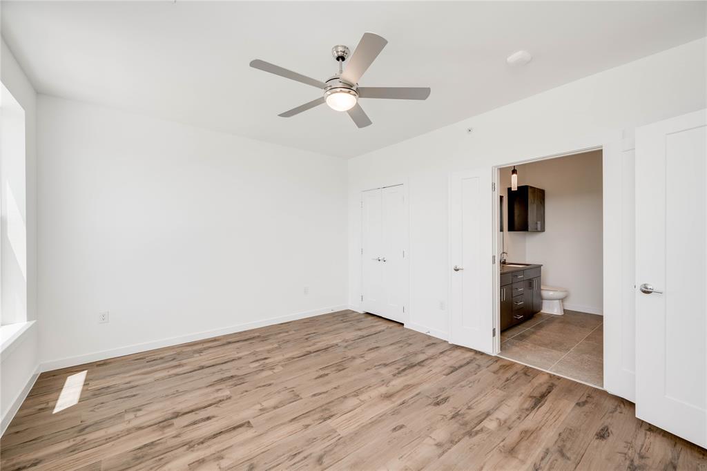 4801 Springdale Road, Unit 1307 Austin, TX 78723 - Photo 11 of 30 an empty room with wooden floor and ceiling fan