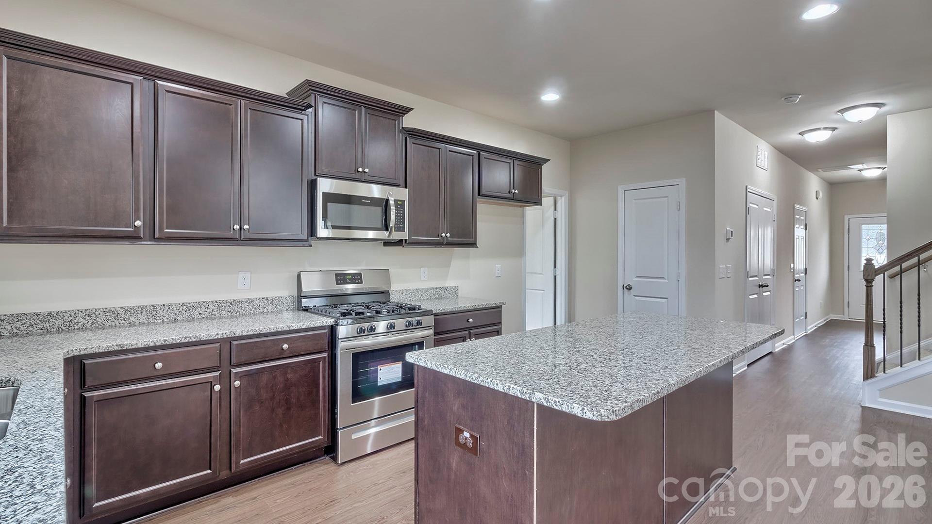 109 Piney Wds Road Fletcher, NC 28732 - Photo 9 of 28 a kitchen with stainless steel appliances granite countertop a stove a sink dishwasher and a refrigerator with wooden cabinets
