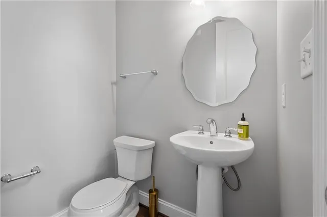 a bathroom with a sink toilet and a mirror