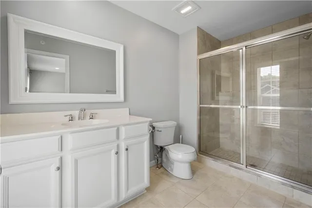 a bathroom with a granite countertop sink a toilet and a mirror