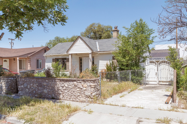 330 West 600th Street South Provo, UT 84601 - Photo 2 of 26 Exterior featuring white horizontal siding, a stone retaining wall, an asphalt shingle roof, a front porch with a gable roof, and a driveway with a metal gate