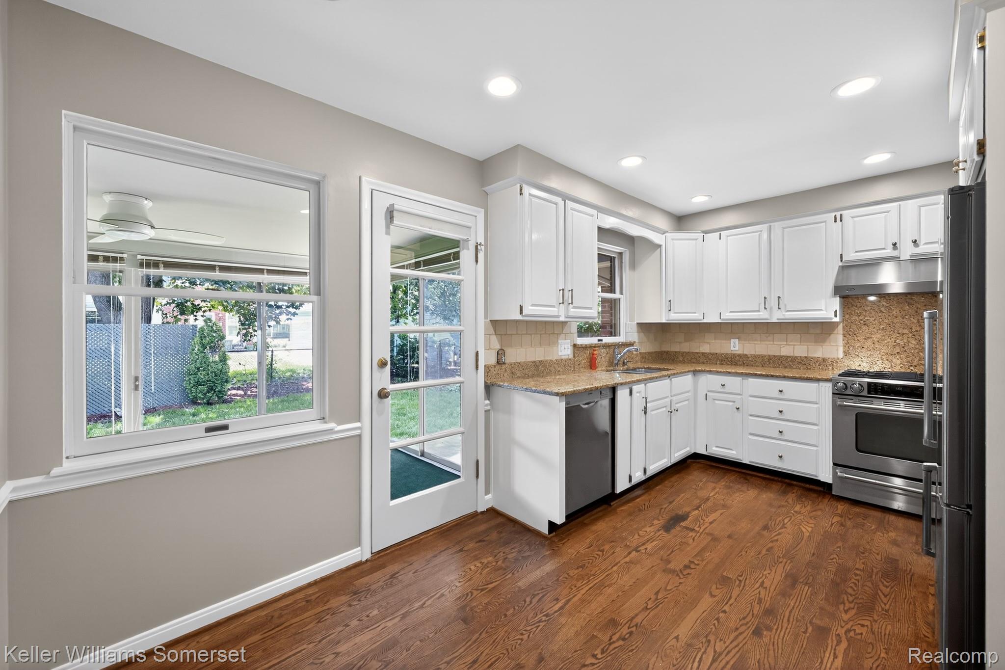 1681 Oxford Road Grosse Pointe, MI 48236 - Photo 8 of 25 Kitchen featuring white cabinetry, stainless steel appliances, tasteful backsplash, dark wood finished floors, and recessed lighting