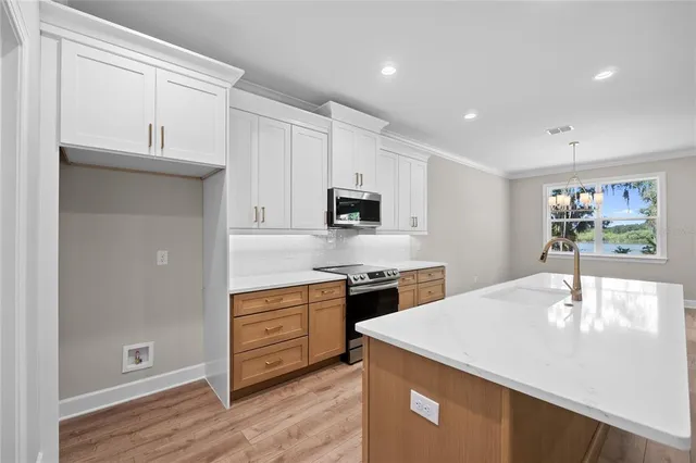 a kitchen with stainless steel appliances granite countertop a sink a stove and a refrigerator