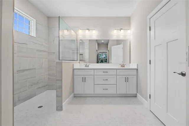 a bathroom with a shower sink and mirror