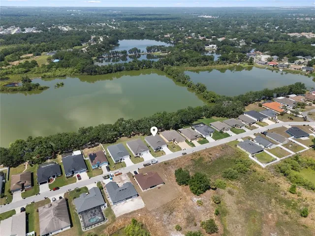 an aerial view of a house with outdoor space and lake view in back