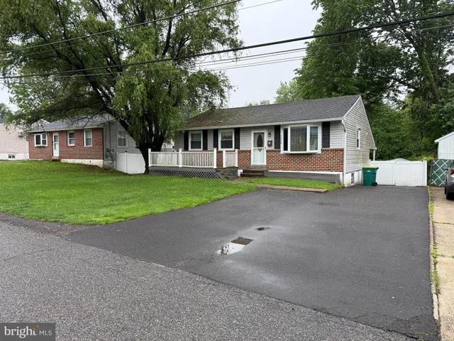 a front view of a house with a garden and trees