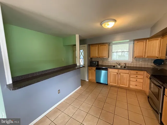 a large kitchen with a sink and cabinets