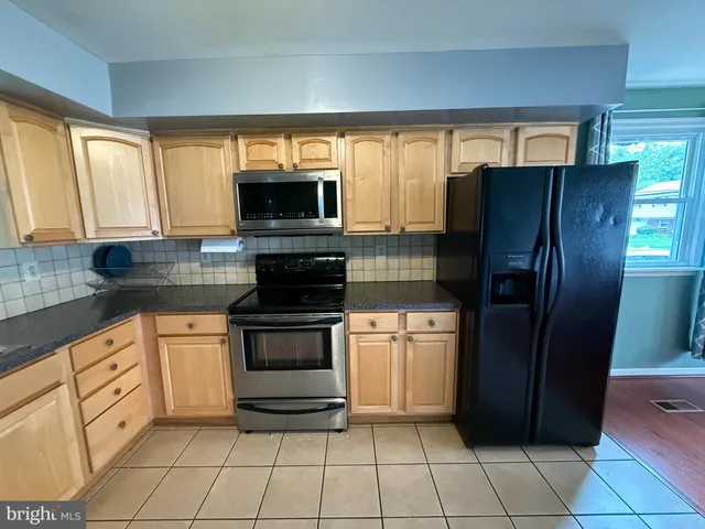 a kitchen with granite countertop a refrigerator and a sink