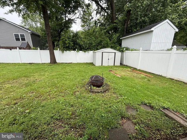 a view of a backyard with a garden and large trees