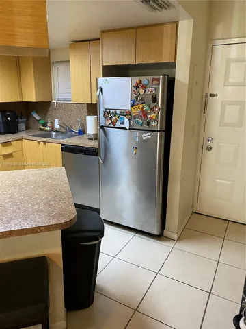 a kitchen with stainless steel appliances granite countertop a refrigerator a sink and a stove