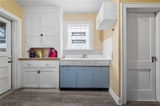 a view of cabinets a sink a window and a mirror