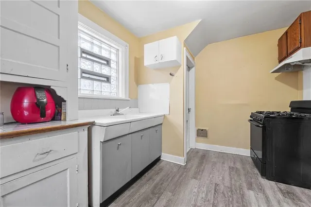 a view of a kitchen with wooden floor and windows
