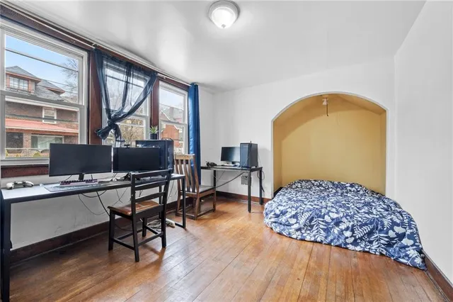 a bedroom with a bed and wooden floor