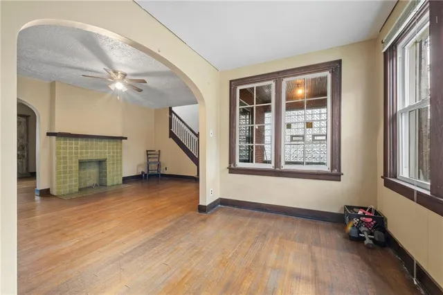an empty room with windows and ceiling fan