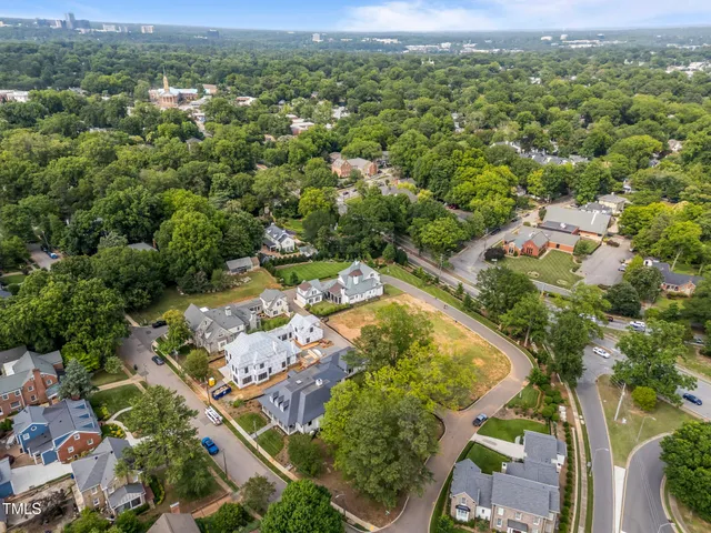 an aerial view of a residential houses with outdoor space and trees