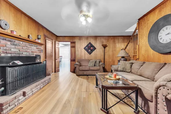 a living room with furniture a flat screen tv and a table with wooden floor