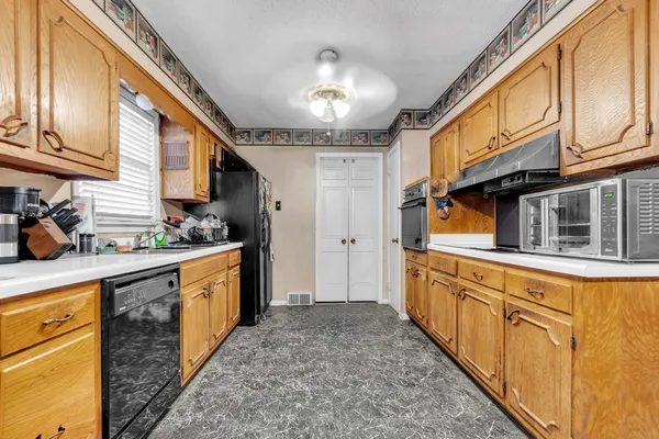 a kitchen with stainless steel appliances granite countertop a sink and cabinets