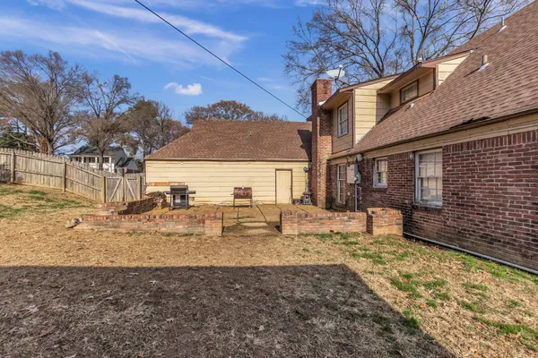 a view of a house with backyard and sitting area