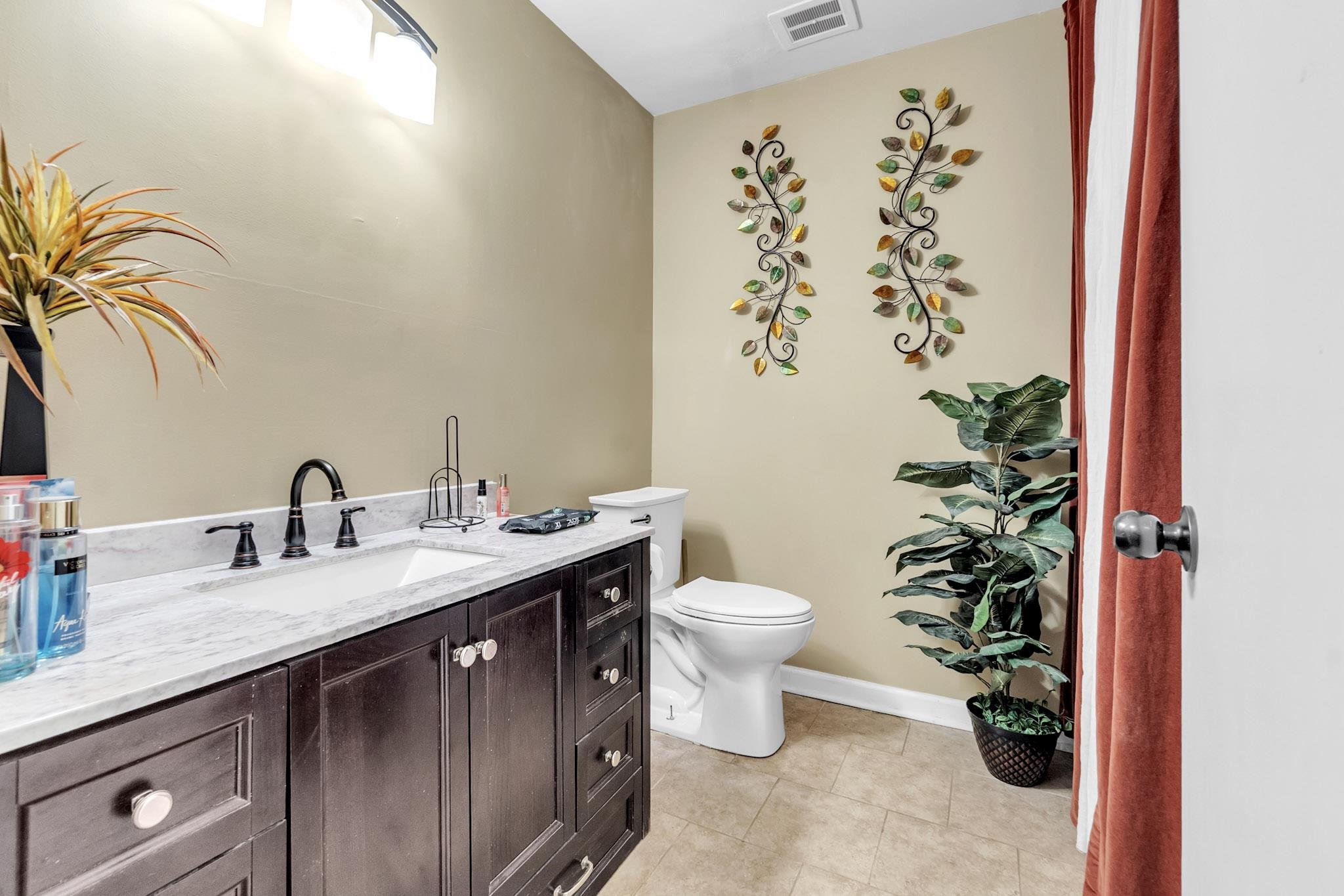 3595 Huckleberry Street Memphis, TN 38116 - Photo 10 of 19 a bathroom with a granite countertop sink and a mirror
