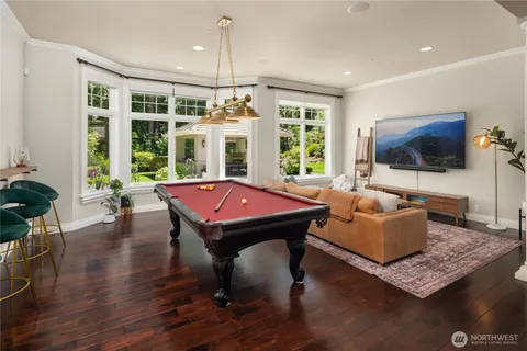 a living room with furniture a flat screen tv and floor to ceiling window